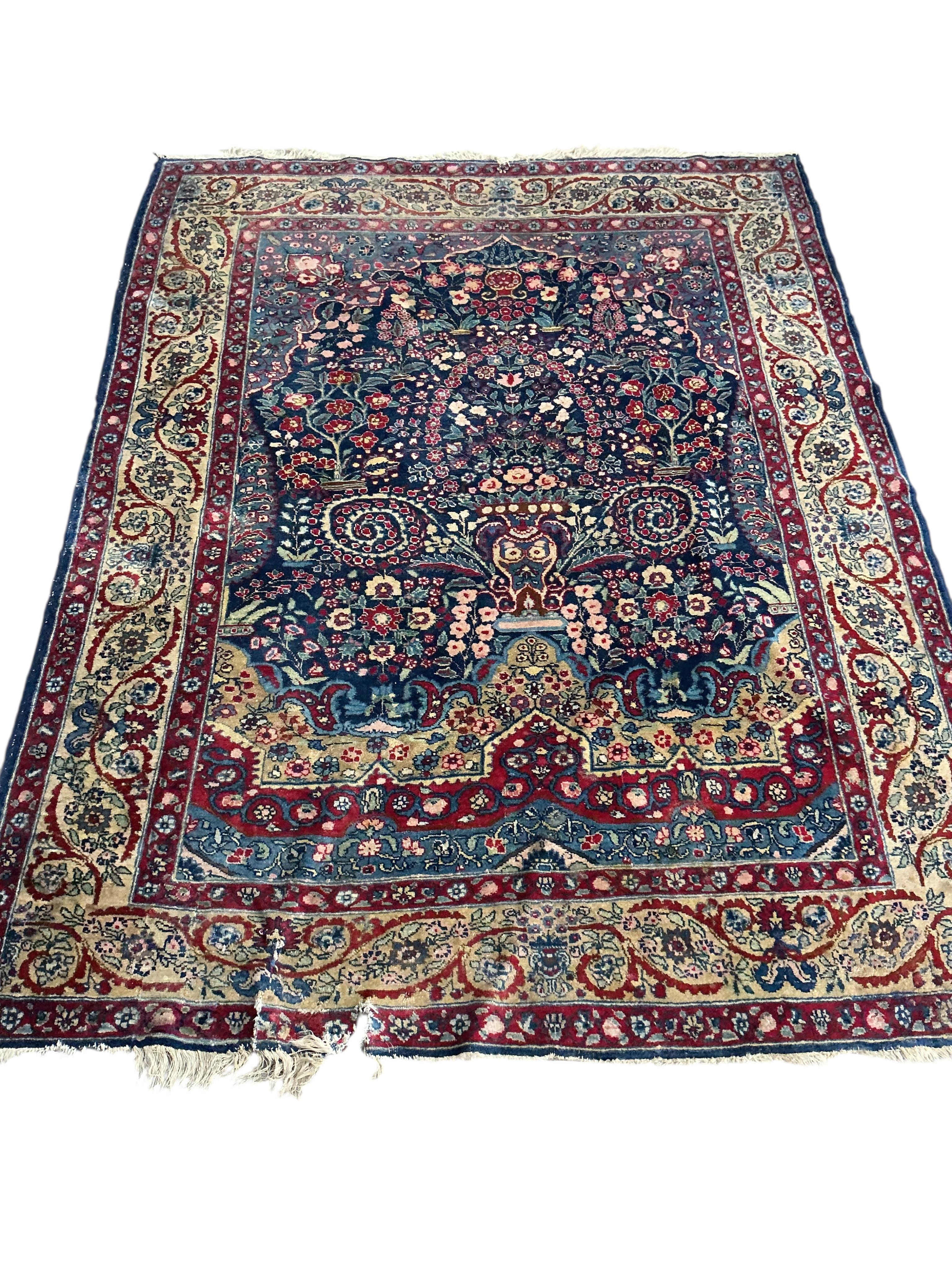 An early 20th century Persian Kashan prayer rug, the central blue ground field with a flower vase within multiple borders, 189 x 145cm